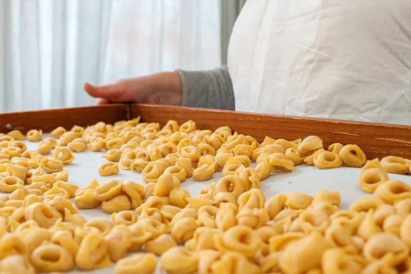 Fresh handmade pasta arranged on a wooden tray